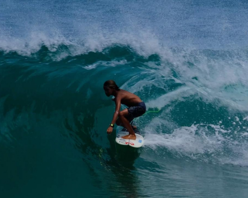 surfista na onda dentro do tubo para a direita de front side em uma prancha branca